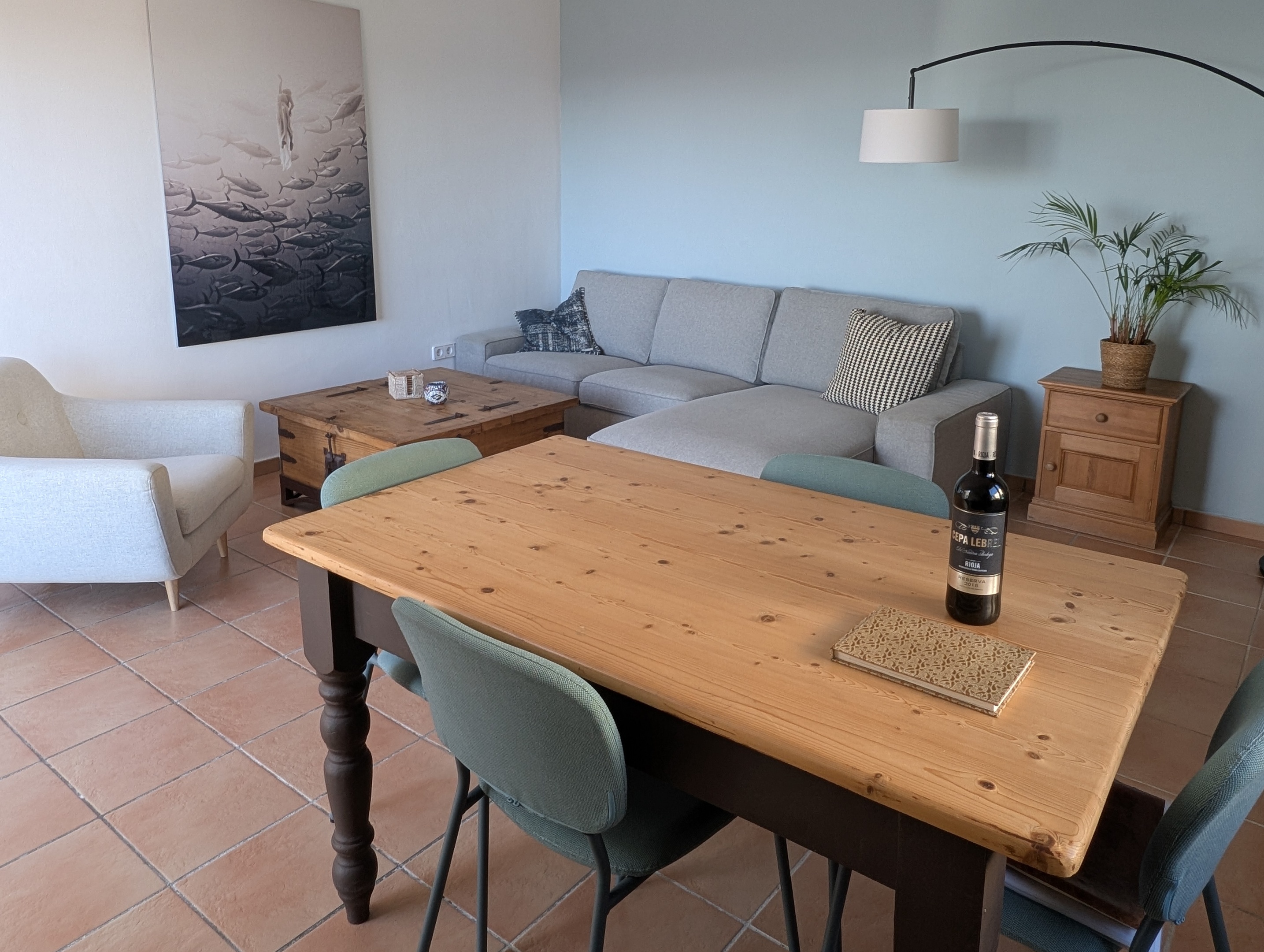 De sfeervolle, lichte woonkamer van Casa Larimar in Almuñécar, met een grote comfortabele loungebank en airco voor zowel verwarming als verkoeling. Door de schuifpui valt veel natuurlijk licht binnen en biedt het directe toegang tot het terras met prachtig zeezicht. Een ideale plek om te ontspannen aan de Costa Tropical.