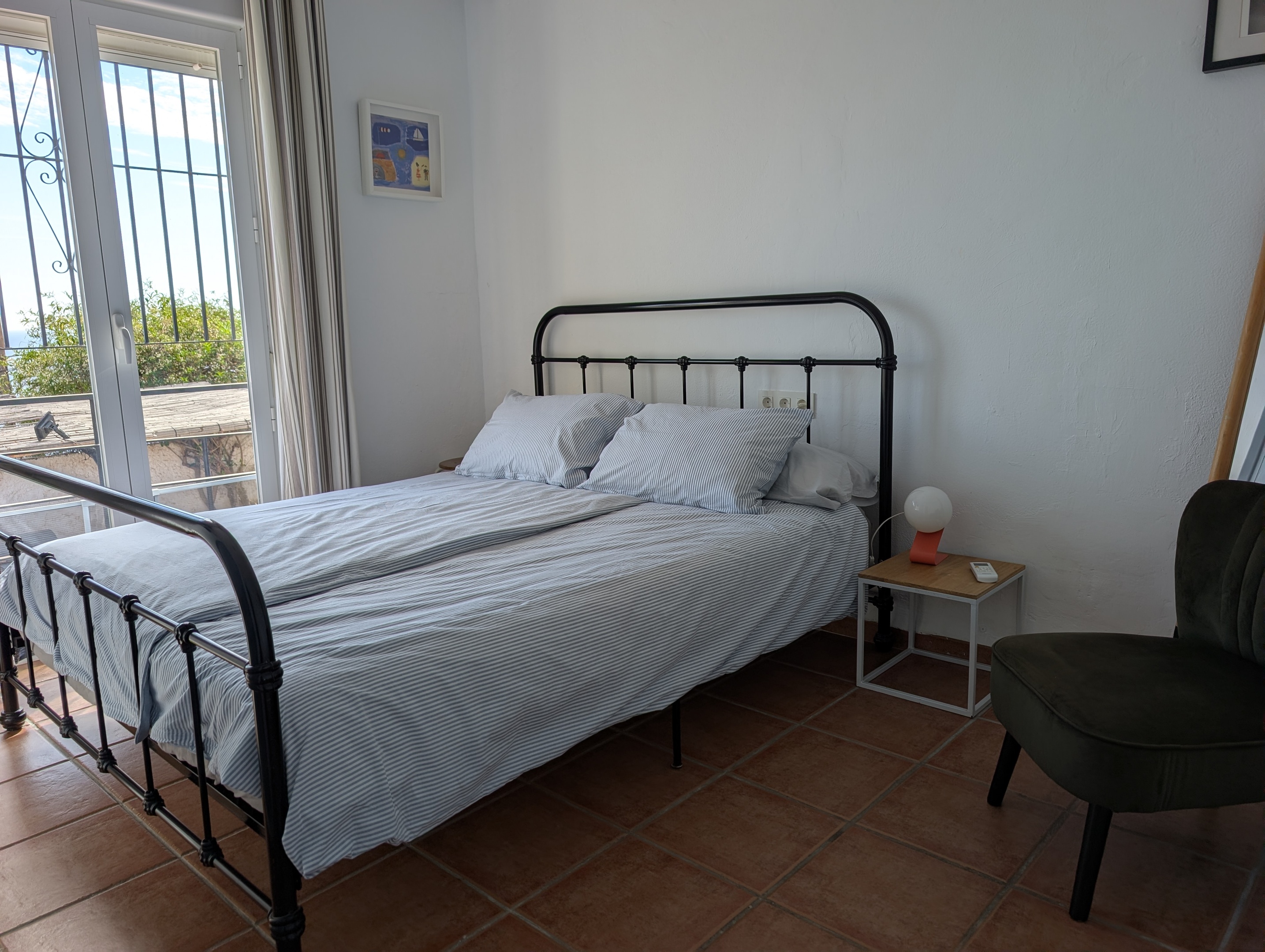 De tweede slaapkamer van Villa Merise beschikt over een comfortabel tweepersoonsbed (1.60 x 2.00), een vaste kast en airco voor verwarming en verkoeling. Via het Franse balkon geniet je van een prachtig uitzicht op zee.