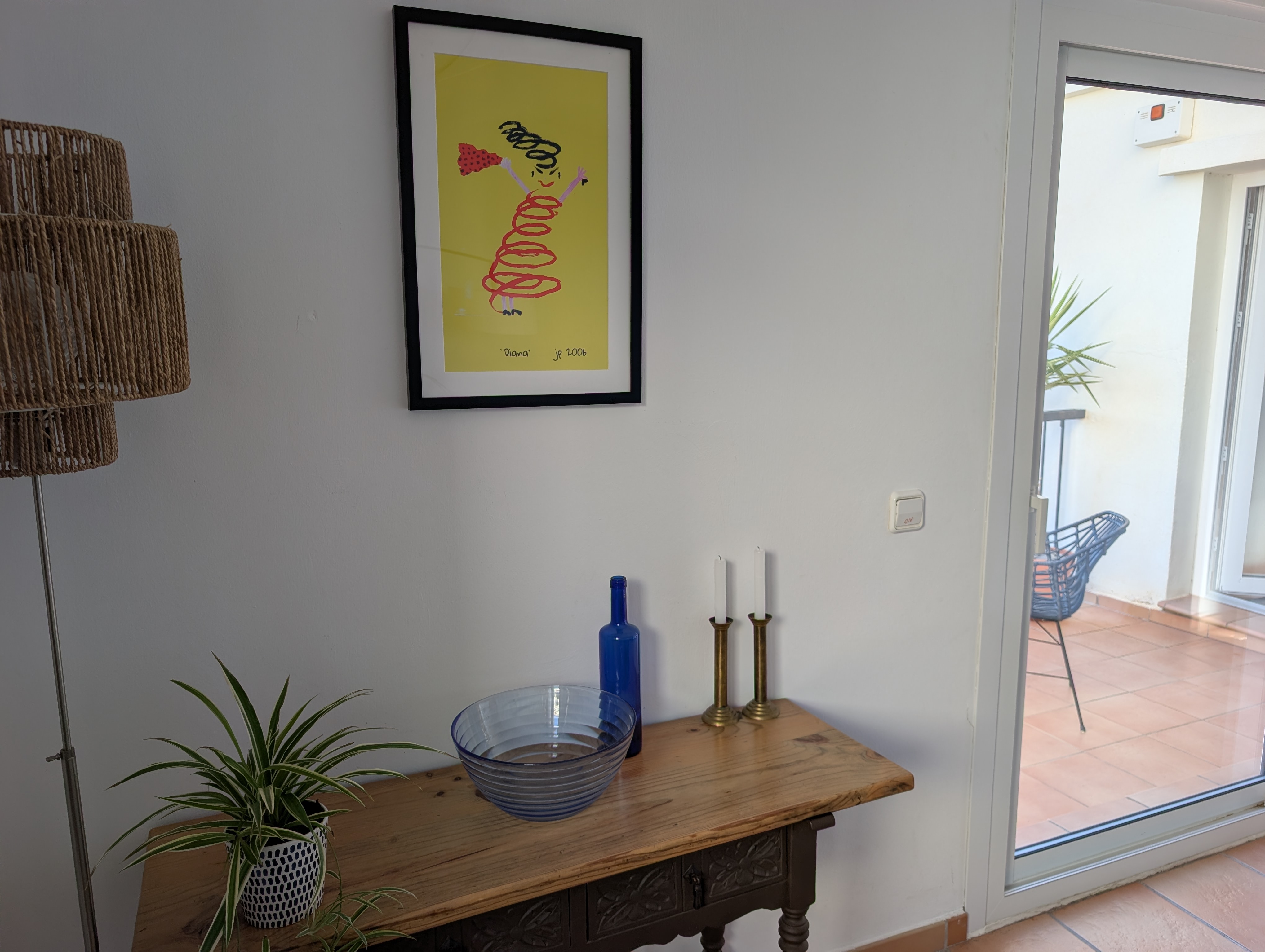 Close-up op het schilderij Diana bij de eethoek en de schuifpui in Casa Larimar