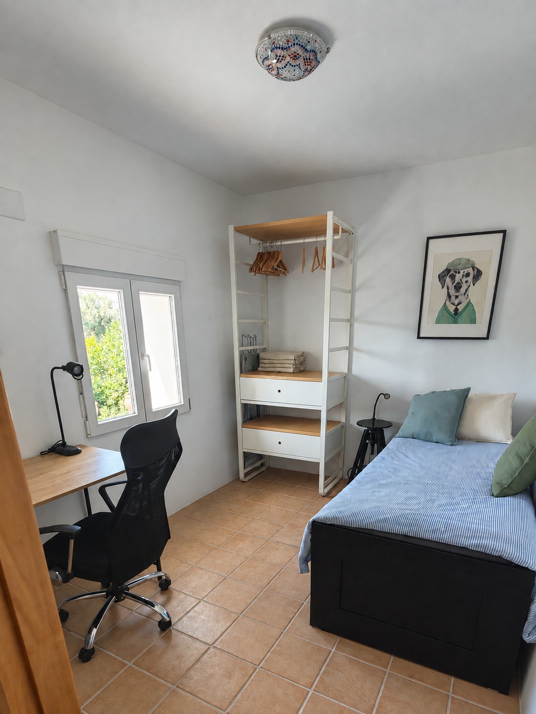 weede logeer- en werkkamer van Casita Klein Zwitserland, met een werkplek, kastruimte, eenpersoons logeerbed en airco voor verwarmen en koelen
