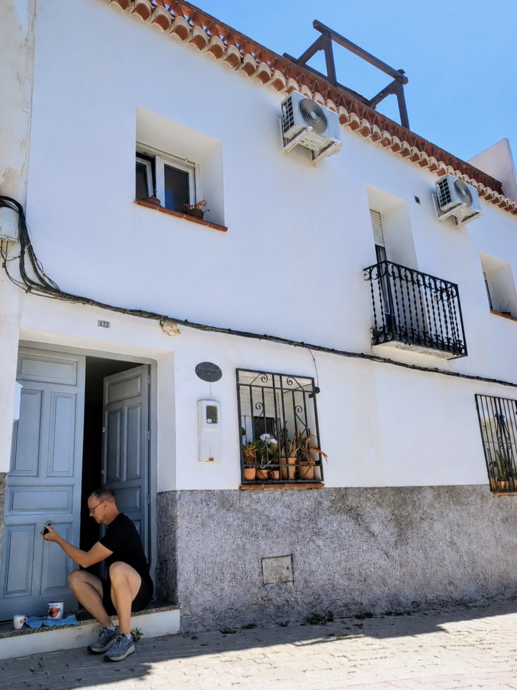 Reijer repainting the front door of Casita Klein Zwitserland in Beznar, Lecrín Valley, Andalusia