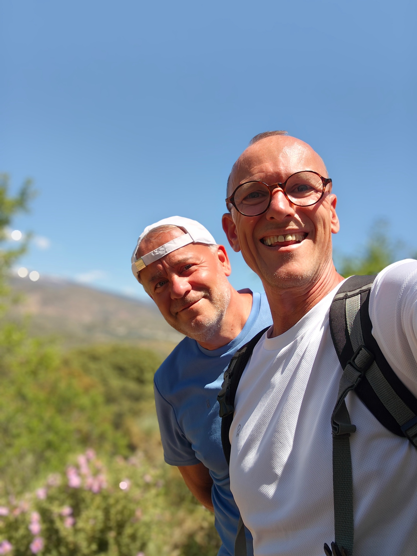 Selfie van Reijer en Johan wandelend in La Alpujarra in Andalusië met zonnig berglandschap op de achtergrond