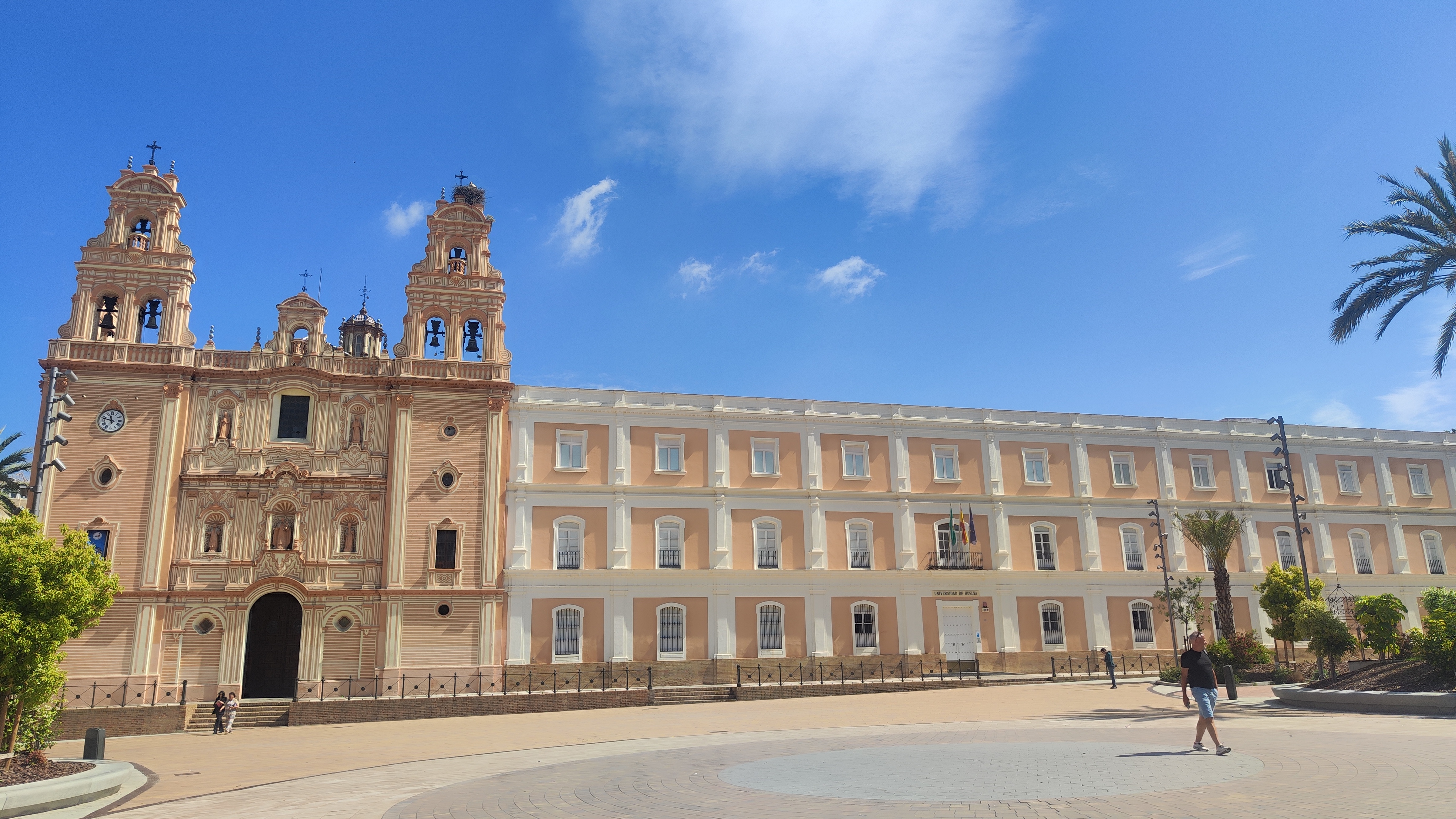 Leeg plein in Huelva met de imposante kathedraal, een ooievaarsnest op één van de torens en een enkele palmboom aan de zijkant.