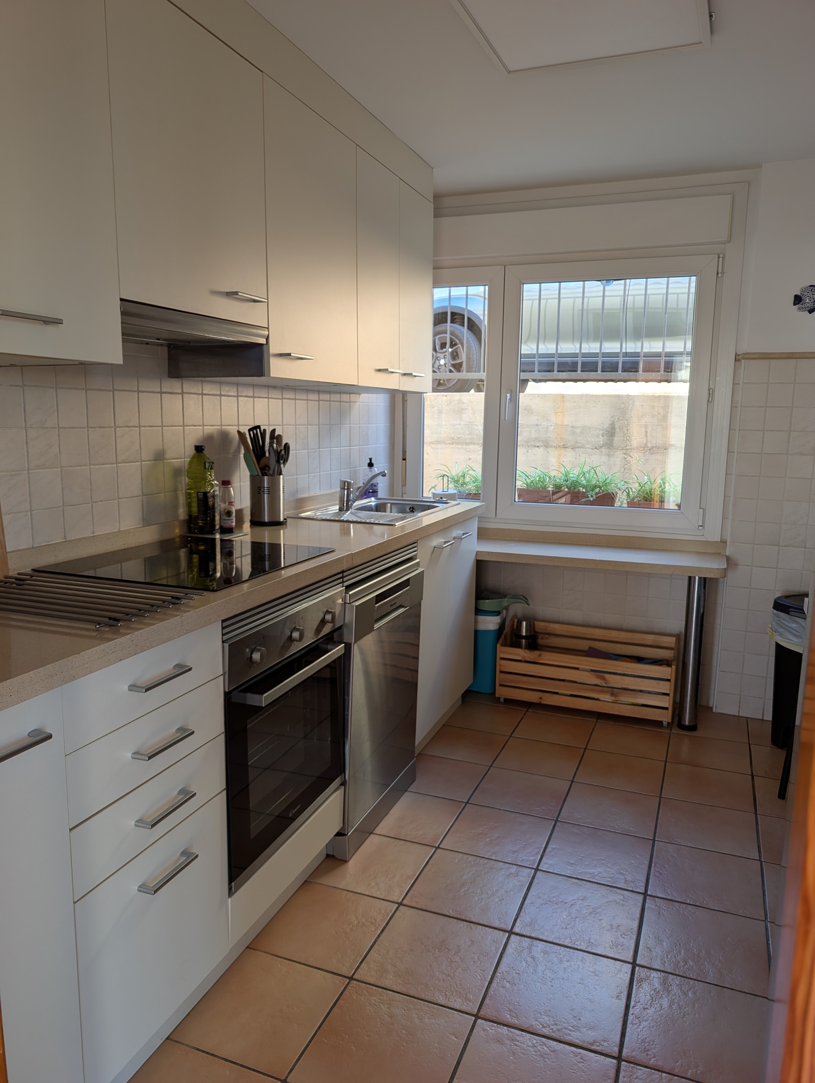 Ruime moderne keuken van Casa Larimar, met inductiekookplaat, oven, vaatwasser en Nespresso-apparaat. Het grote raam biedt uitzicht op de straatzijde, waardoor de ruimte veel natuurlijk licht ontvangt.