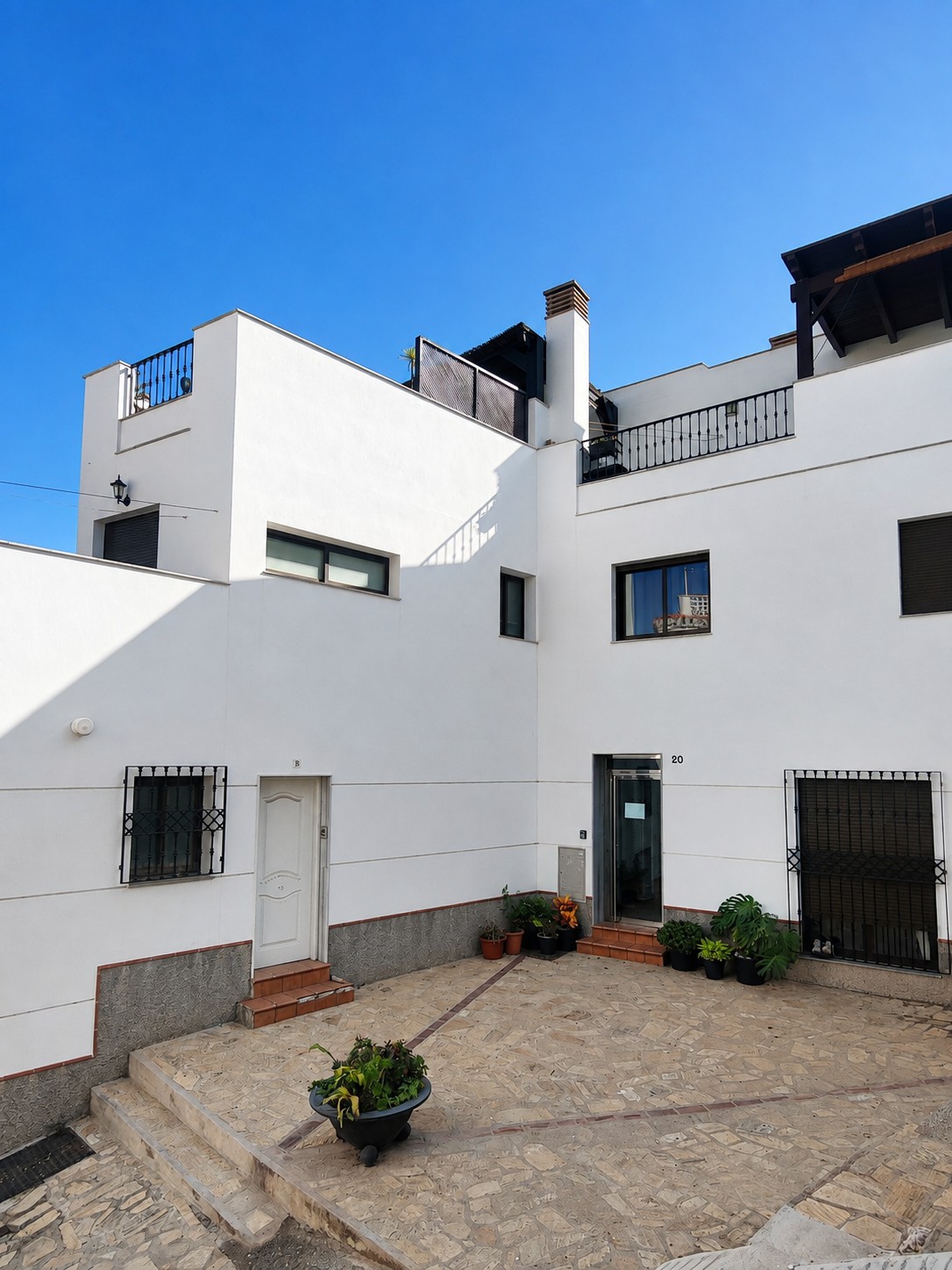 Entree van het appartementengebouw waar Ático Lolapaluza zich bevindt, met toegang via een charmant pleintje in Salobreña