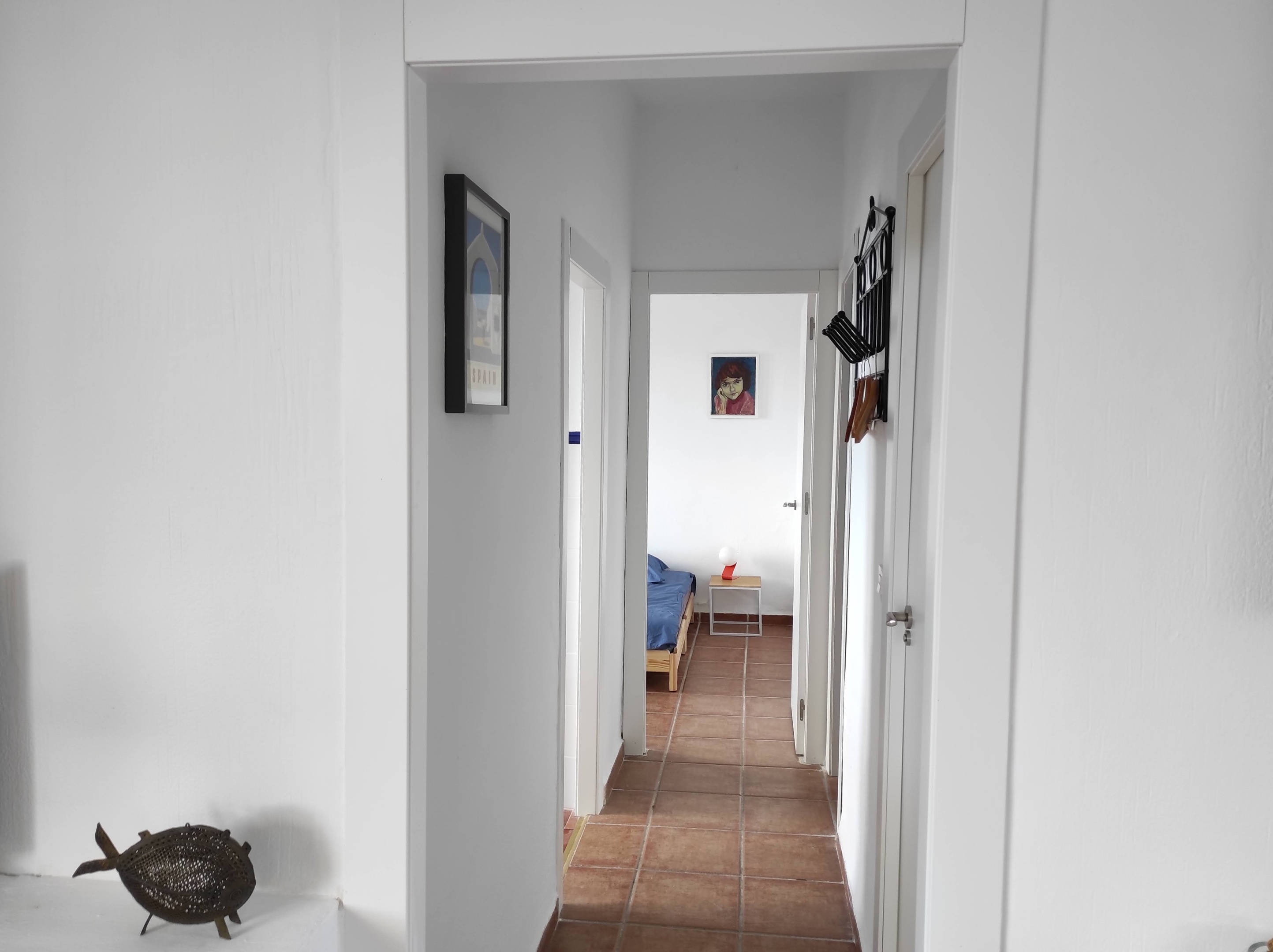 Vanuit de woonkamer van Villa Merise een blik op de gang die leidt naar de keuken, de badkamer en de twee slaapkamers. Eén van de slaapkamers beschikt over een werkplek, ideaal voor remote werken of schrijven